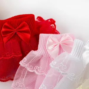 Gros plan de chaussettes bébé avec d'élégants volants en dentelle et nœuds en satin