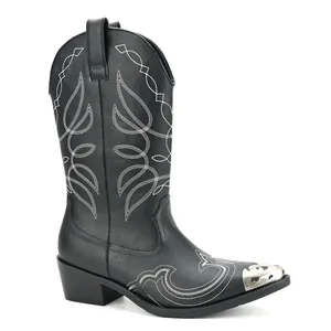 Close-up detail of black western cowboy boots with embroidery and metal toe