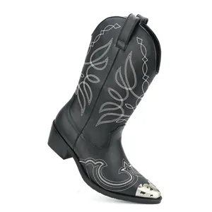 Detailed view of vintage black Western boots with white embroidery and metal toe cap