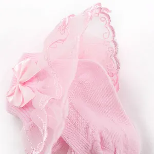 Détail de chaussettes roses pour bébé fille avec dentelle double et un nœud délicat
