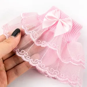 Vue détaillée des volants en dentelle rose à double couche et du nœud en satin