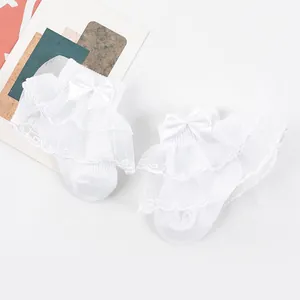 Gros plan sur des chaussettes blanches bébé fille avec dentelle double et nœud
