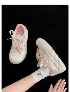 Primer plano de zapatillas con plataforma blancas y rosas para niña con estrella y lazo