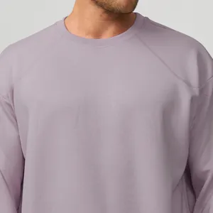 Gros plan sur un sweat-shirt mauve clair à col rond pour homme avec manches raglan.