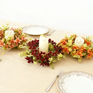 Kaarsenringen met bloemen in Europese retrostijl op een elegante eettafel geplaatst
