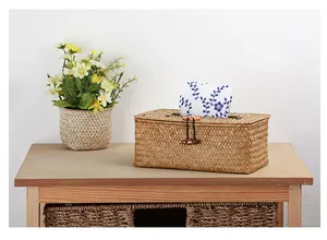 Handgewebte Taschentuchbox aus Naturstroh auf einem rustikalen Holztisch dekoriert
