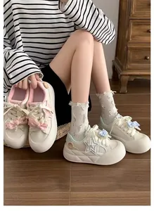 Vista detallada de zapatillas blancas con plataforma para niñas, lazos y estrellas.