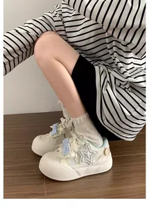 Detalle de zapatillas de plataforma blancas para niñas con estrella y lazo