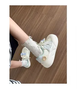 Primer plano de zapatillas blancas de plataforma para niñas con estrellas y lazos