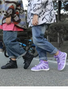 Detail view of purple and black fleece-lined snow boots worn by children outdoors.