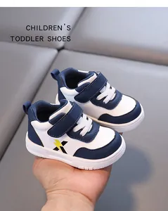 Detail view of navy and white toddler leather shoes with soft non-slip sole in hand