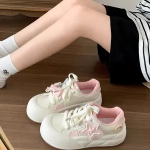 Zapatillas con plataforma para niña con detalle de estrella rosa y lazo en suelo