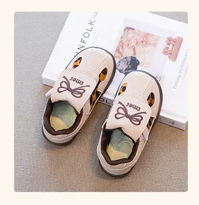 Vista detallada de zapatillas de leopardo para niños con adorno de lazo en ante beige