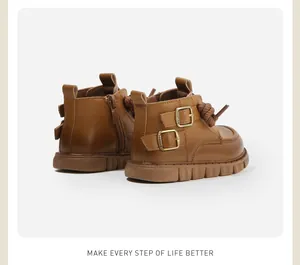 Vue latérale détaillée de bottines Martin pour enfants en similicuir marron à boucles dorées.