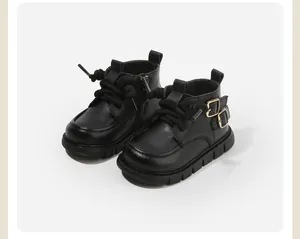 Gros plan de bottines Martin noires pour enfants avec boucle et semelle antidérapante