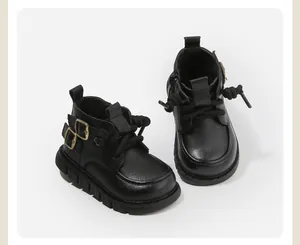 Vue détaillée des bottines Martin noires pour enfants avec boucle latérale et semelle souple.