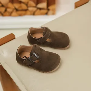 Detailed view of brown suede children's Mary Jane shoes with adjustable T-strap buckle
