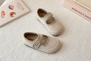 Close-up of beige French retro Mary Jane shoes for girls on textured cloth