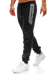 Detail van zwarte heren joggingbroek met grijs zijpaneel en witte sneakers