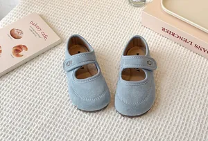 Close-up of light blue suede Mary Jane shoes for girls with velcro strap