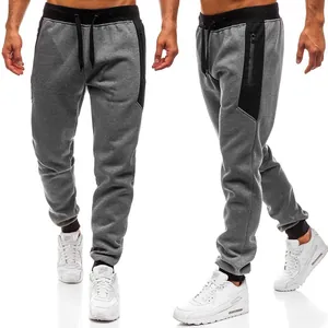 Detail van grijze heren joggingbroek met zwarte panelen en zakken met ritssluiting