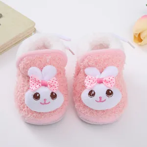 Detail showing cute pink plush baby shoes with rabbit face and bow for newborns