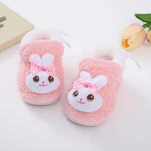 Close-up of pink plush baby shoes featuring a cute bunny design and warm fleece lining.
