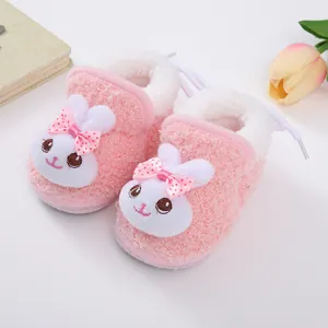 Detail view of plush pink baby shoes with cute bunny face and warm fleece lining