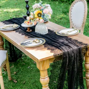 Detailed macro view of black lace table runner displayed on a rustic wooden table