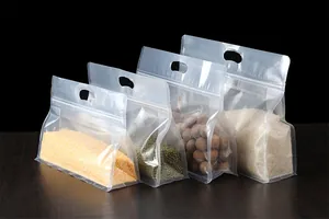 Vista detallada de cuatro bolsas transparentes con asas rellenas de varios tipos de cereales.