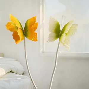 Vue détaillée de deux papillons élégants en papier dégradé dans une pièce lumineuse.