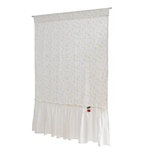 Close-up detail of white cotton ruffled door curtain with orange dots and cherry charm