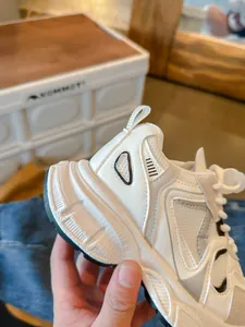 Κοντινό πλάνο λευκών γυναικείων chunky sneakers με στρώσεις στο επάνω μέρος και σόλα