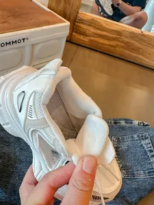 Κοντινή λεπτομέρεια λευκού chunky sneaker με διχτυωτό υλικό και εσωτερική επένδυση