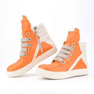 Detail view of orange high-top sneakers with thick laces and a side zipper closure.