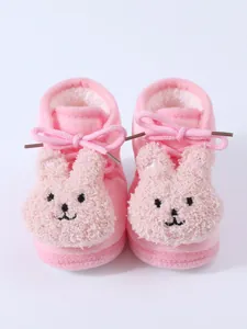Close-up view of pink plush winter baby boots featuring a cute bunny face design