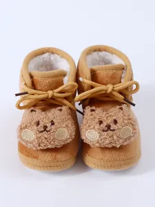 Detail view of cute bear plush decoration on warm winter baby boots with fleece lining