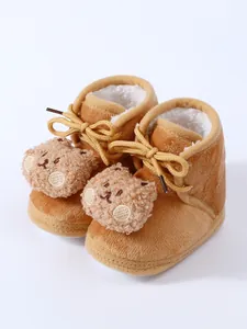 Detail view of warm brown baby winter boots featuring plush bear decor and soft fleece lining