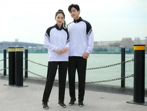 Couple asiatique portant des survêtements de sport noir et blanc dans un décor urbain extérieur