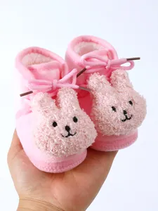 Close-up of pink fleece-lined baby winter shoes with cute rabbit face design