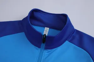 Détail en gros plan du col d'une veste de sport bleue avec fermeture éclair et étiquette