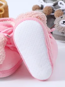 Detail of non-slip sole on warm pink plush baby shoes for winter