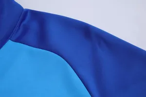 Vue détaillée montrant le tissu bicolore bleu et la couture de la manche raglan de la veste