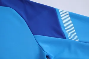 Gros plan d'une manche de veste de sport bleue montrant la texture et les rayures