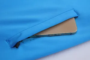 Gros plan détaillé de la poche zippée d'une veste de sport bleue avec smartphone