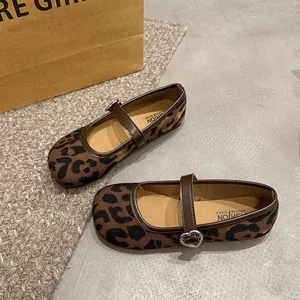 Close-up detail of leopard print Mary Jane shoes featuring a silver heart buckle strap