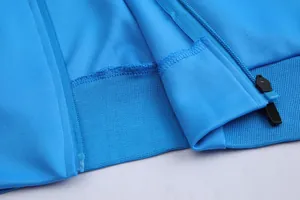Gros plan d'une veste de sport bleue montrant la fermeture éclair et l'ourlet côtelé