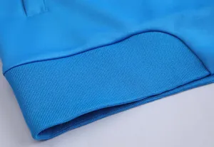Gros plan sur l'ourlet côtelé d'une veste de sport bleu vif avec coutures de précision