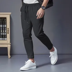 High-quality detailed shot of men's black slim-fit drawstring business casual trousers