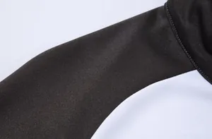 Gros plan sur la couture d'épaule d'une veste de survêtement de sport bicolore noir et blanc.